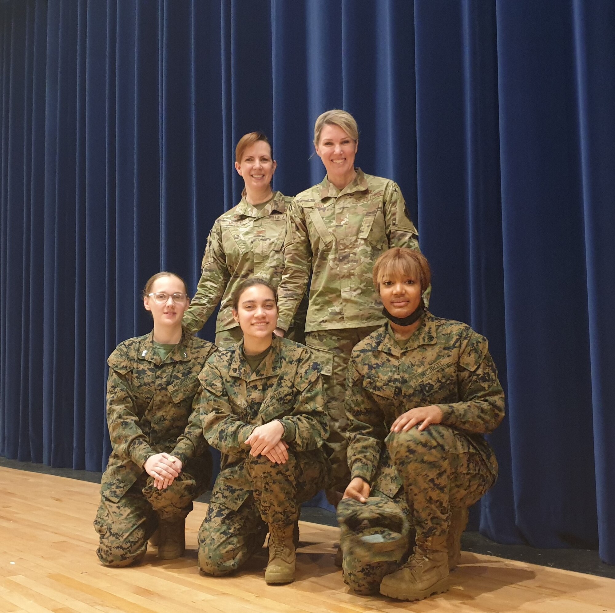 A group of women wearing military uniforms pose for a picture.