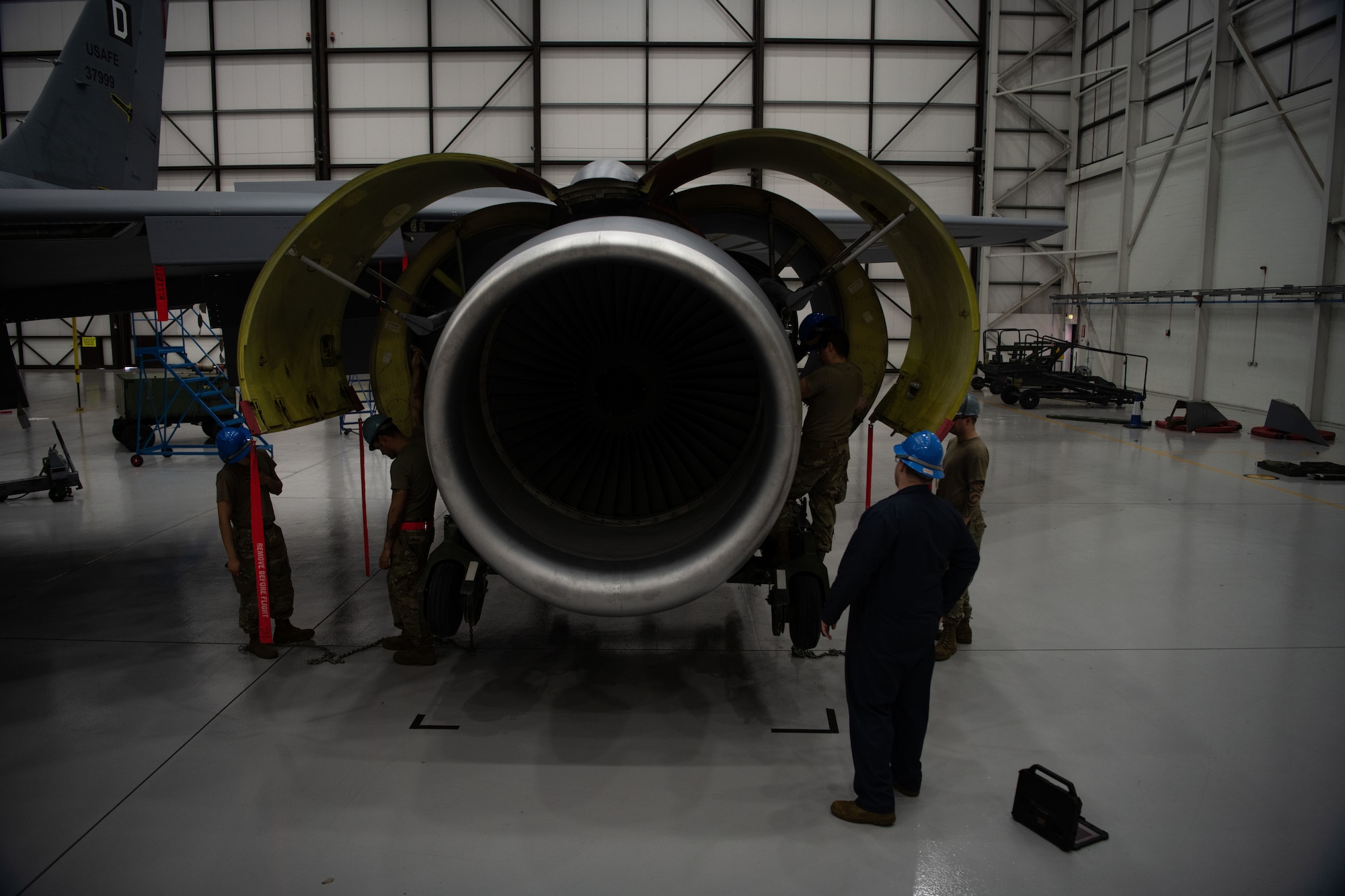 The engine raising process requires precise coordination between a team of at least four Airmen to ensure proper engine installment.