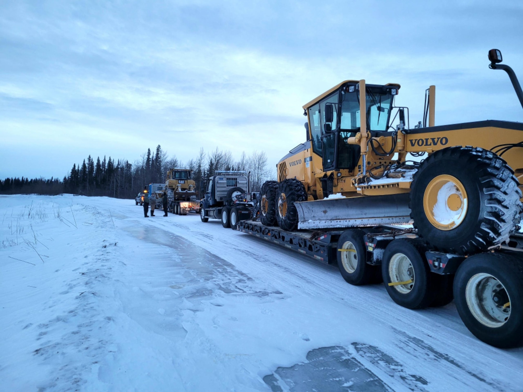 A Volvo grader and a CAT 950 Dozer are hauled from Eielson Air Force Base, Alaska, to Delta Junction