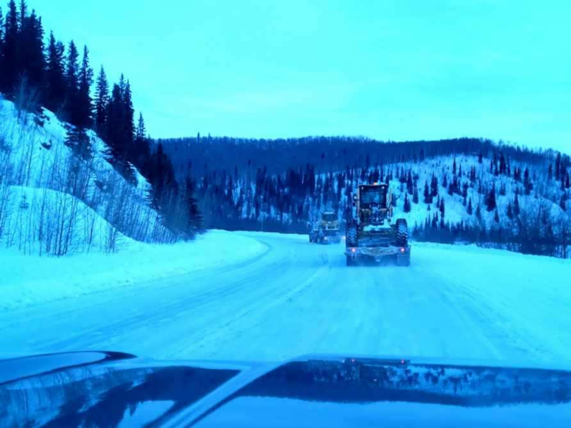 A Volvo grader and a CAT 950 Dozer are hauled from Eielson Air Force Base