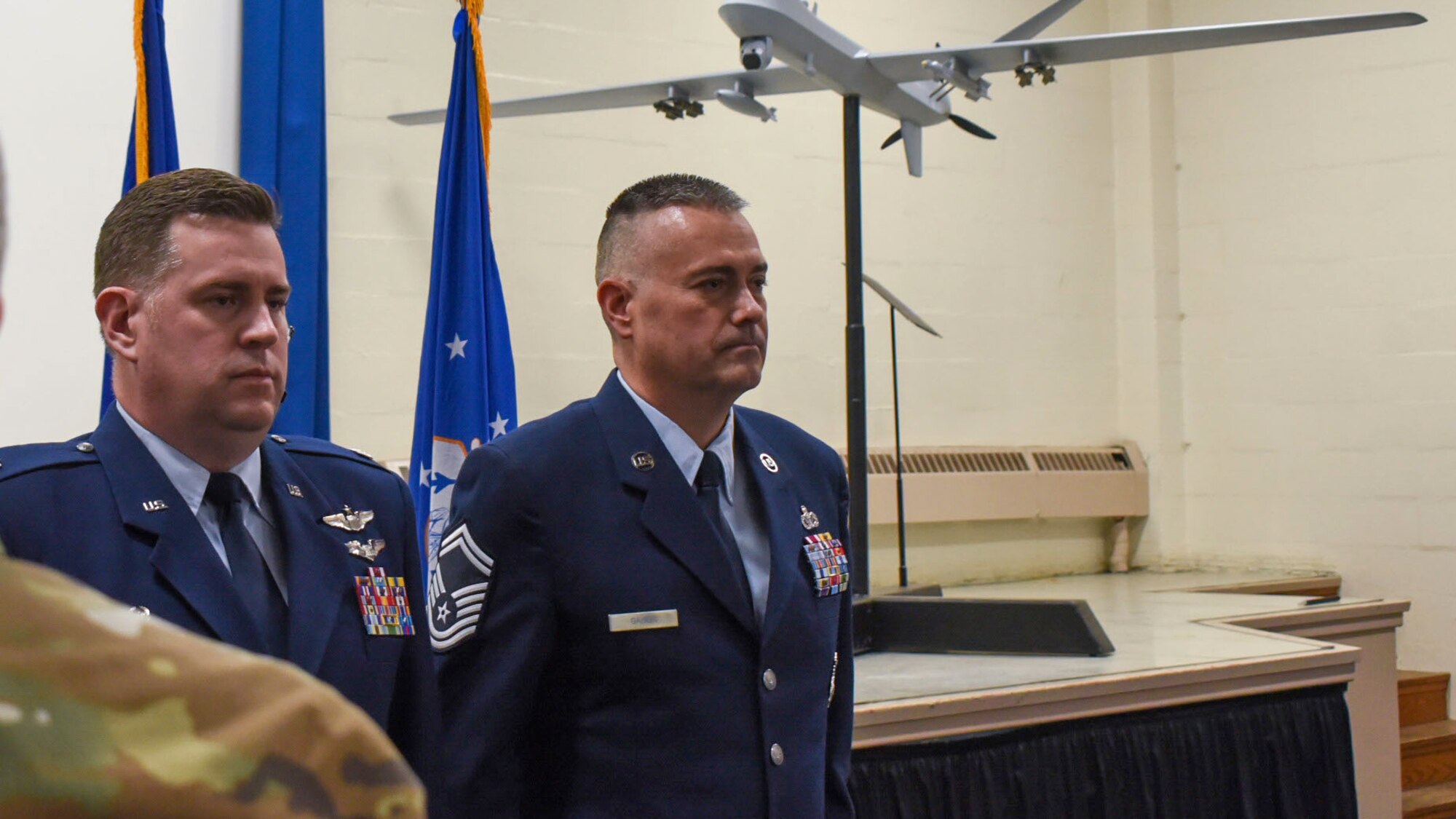 Two men in Air Force dress blues stand at attention.