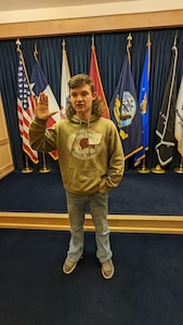 A man raises his right hand, taking the oath of enlistment to join the Army.