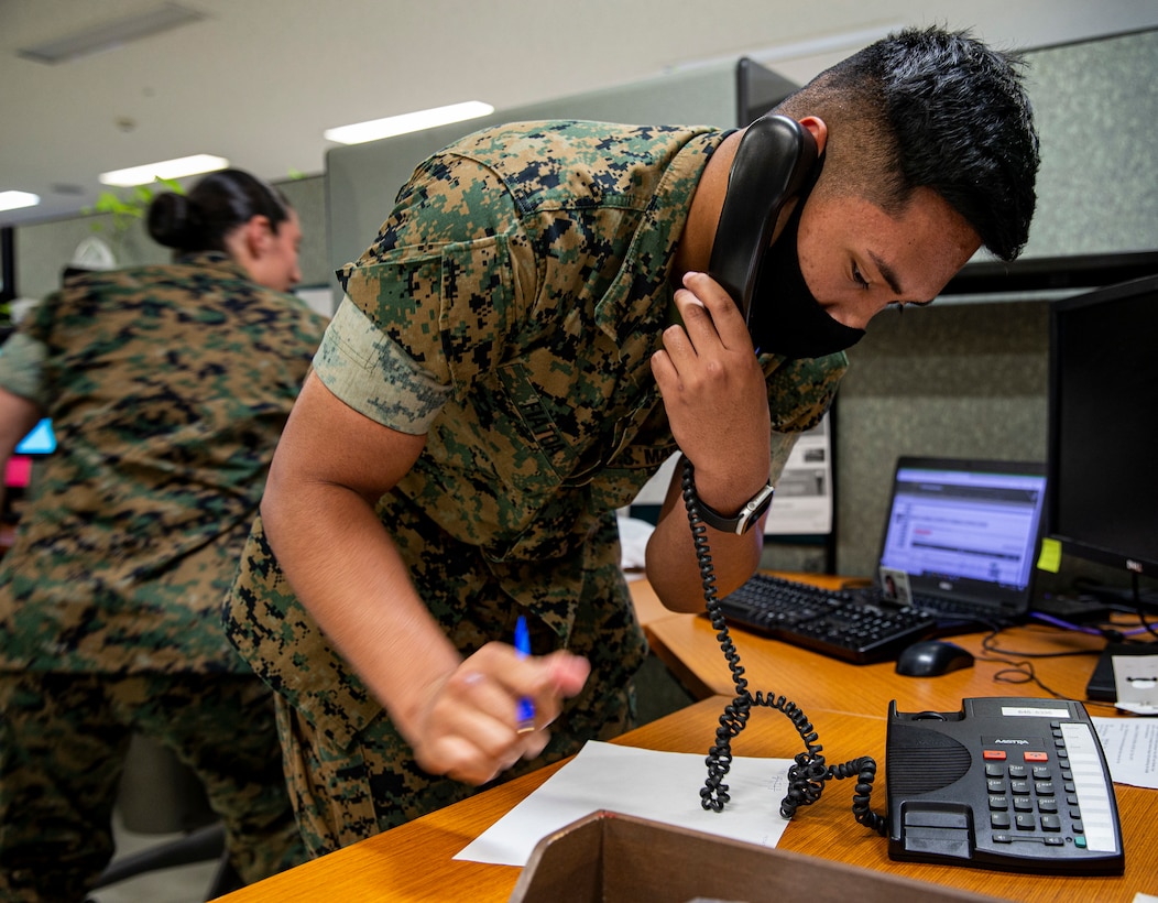 U.S. Marine Corps Lance Cpl. Xavier Fiatoa, a distribution management specialist with Headquarters and Support Battalion, Marine Corps Installations Pacific, accommodates a caller in the Passenger Travel Office on Camp Foster, Okinawa, Japan, April 14, 2021. The PTO is a section of the Distribution Management Office that assists service members, Department of Defense civilians, and their families with their permanent change of station and temporary additional duty travel needs. Fiatoa is a native of Ewa Beach, Hawaii.