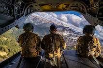 (Left to Right) Capt. Derek Houser, Capt. Nicholas Brischler, and Sgt. Kevin Pagan enjoy the view from the ramp of a CH-47 Chinook from B Co, 1-214th General Support Aviation Battalion during a high-altitude training flight in the Bavarian Alps, Germany on May 4, 2020. (U.S. Army photo by Maj. Robert Fellingham)
