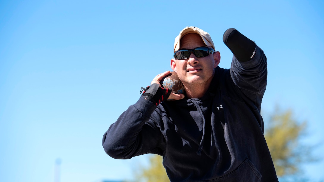 Wounded warrior practices shot put.