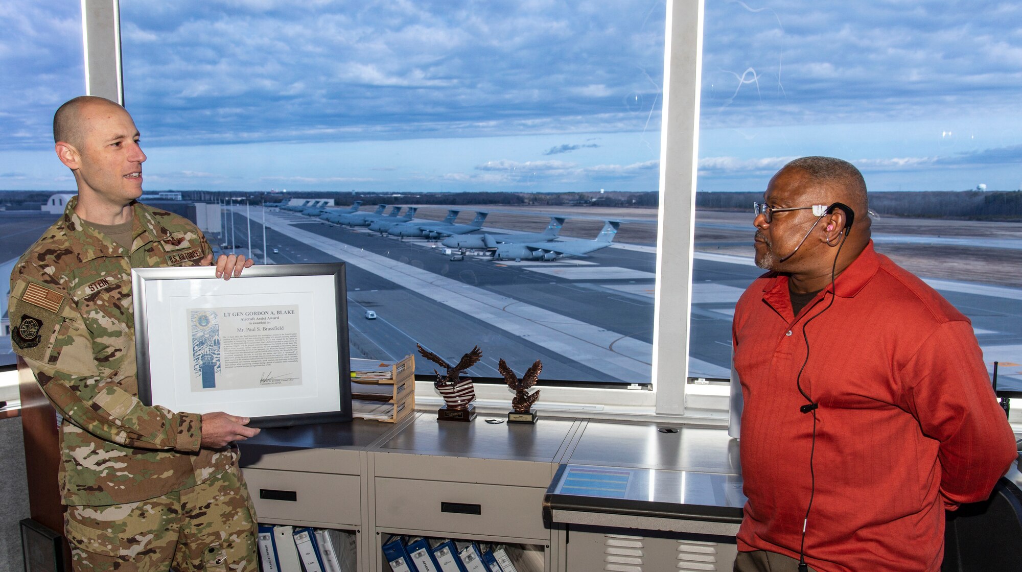 Lt. Col. Andrew Stein, left, 436th Operations Group deputy commander, presents Paul Brassfield, 436th Operations Support Squadron air traffic control tower watch supervisor, with the Lt. Gen. Gordon A. Blake Aircraft Assist Award at Dover Air Force Base, Delaware, March 3, 2022. Brassfield's quick reaction, exceptional crew resource management and dedication to the tower team concept prevented a potential aircraft mishap and significant loss of life. (U.S. Air Force photo by Roland Balik)