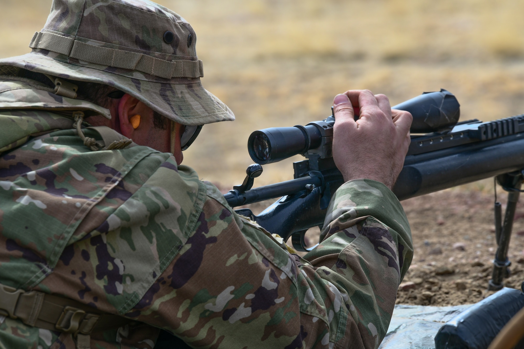 An Airmen adjusts his weapons scope