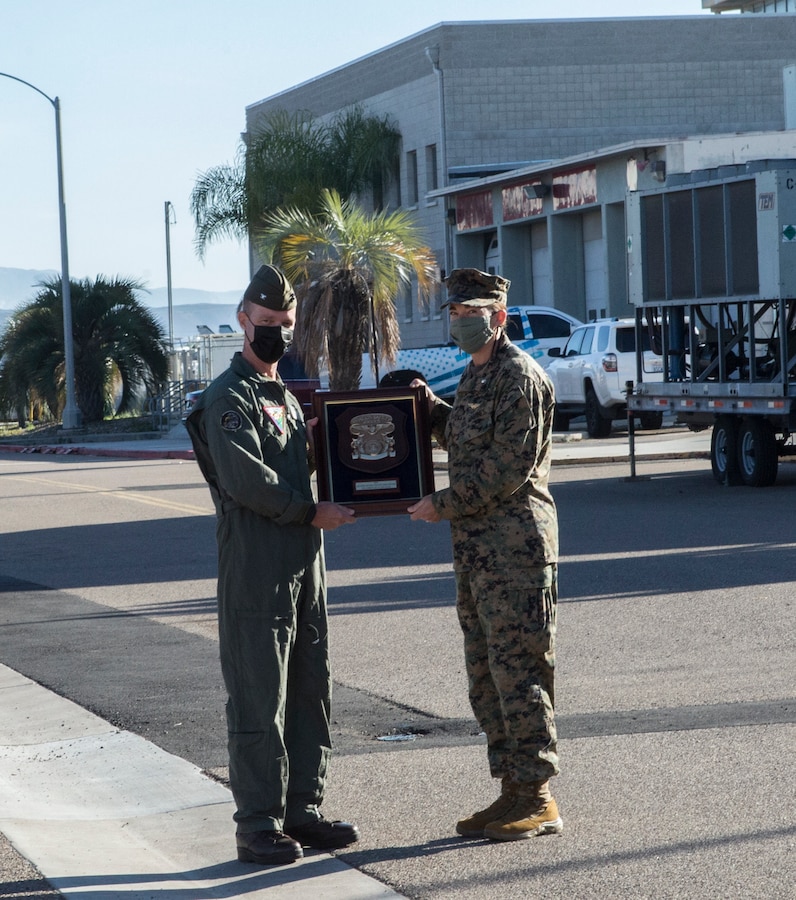 U.S. Marine Corps Col. Thomas M. Bedell, the commanding officer of Marine Corps Air Station Miramar, presents the 2020 Chief of Naval Operations Aviation Safety Award to Lt. Col. Christine M. Houser, the commanding officer of Headquarters and Headquarters Squadron, MCAS Miramar, Jan. 4, 2022, on MCAS Miramar, San Diego, California. The squadron was awarded for the exceptional performance of its primary operational-support airlift mission. The CNO Aviation Safety Award is presented annually to the Navy and Marine Corps aviation units that demonstrate exceptional safety excellence. (U.S. Marine Corps photo by Lance Cpl. Nayomi Koepke)