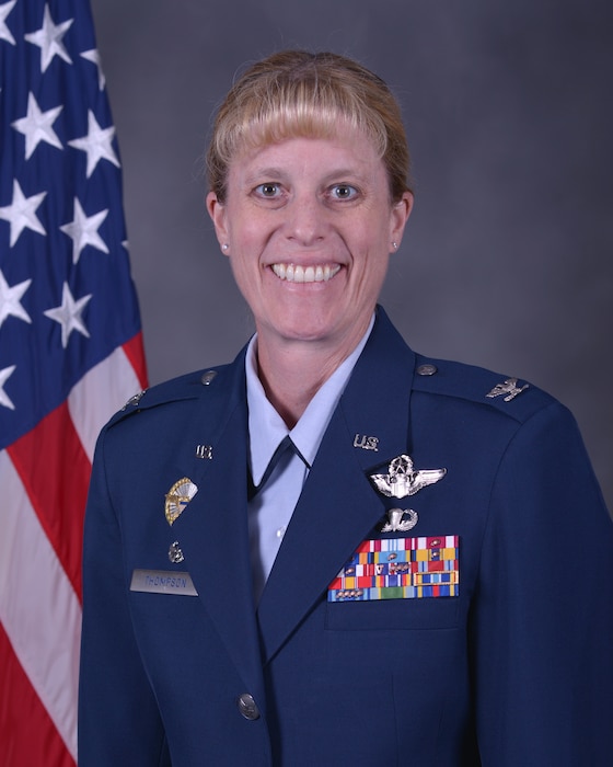 Head shot of female Airman in front of an American flag.