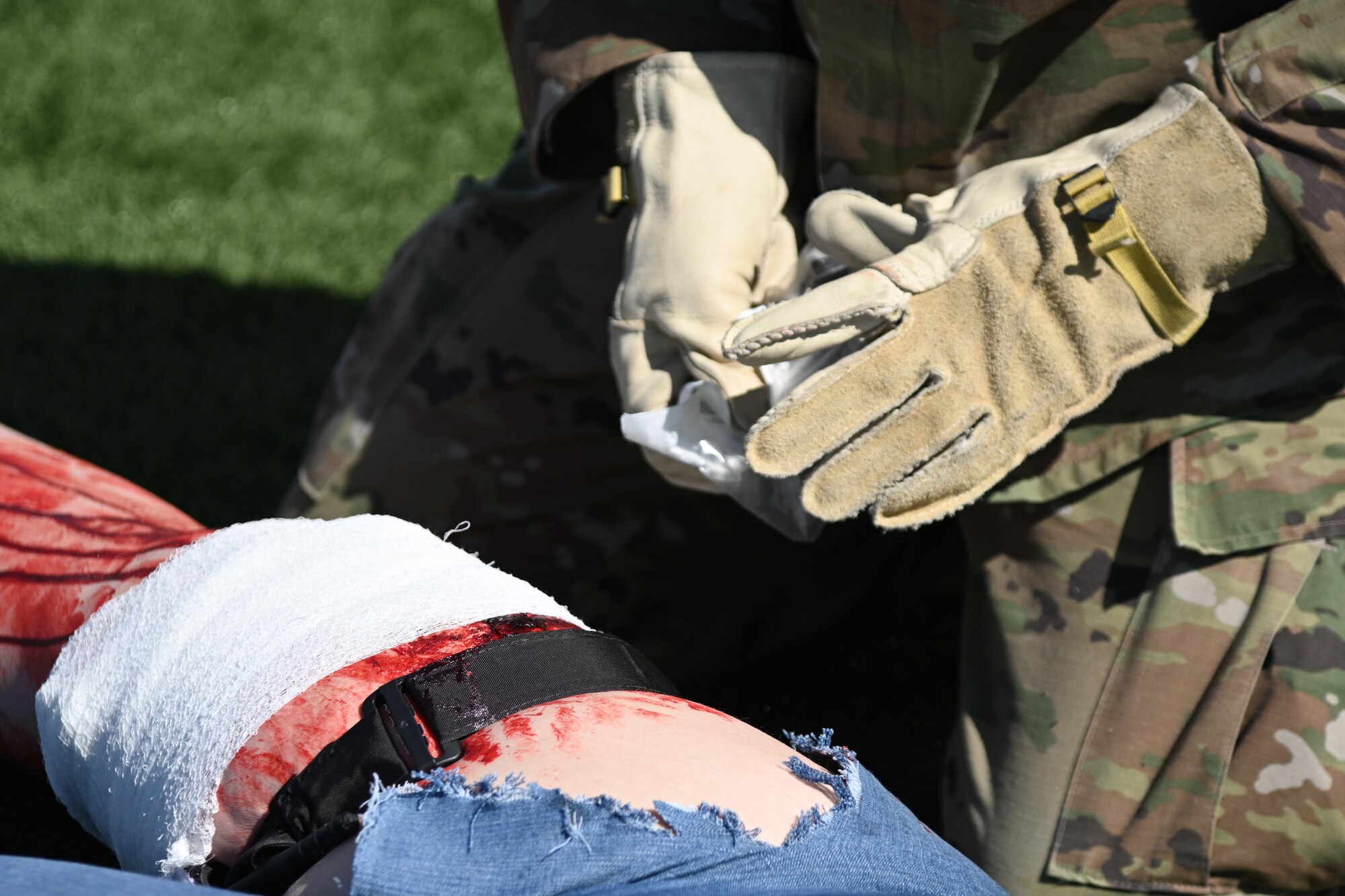 An Airman applies gauze to a simulated wound.