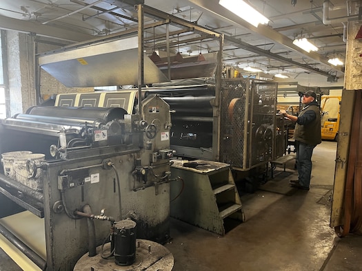 Jerad Vogt, Defense Logistics Agency Document Services employee, runs a one-of-a kind Flexo graphic printing press to print 25-meter silhouette targets at a DLA printing facility at Rock Island Arsenal, Ill., March 11, 2022. The Defense Logistics Agency is now the Defense Department’s primary provider of printing services, office print devices and electronic conversion services. (Defense Logistics Agency photo by John Turner)