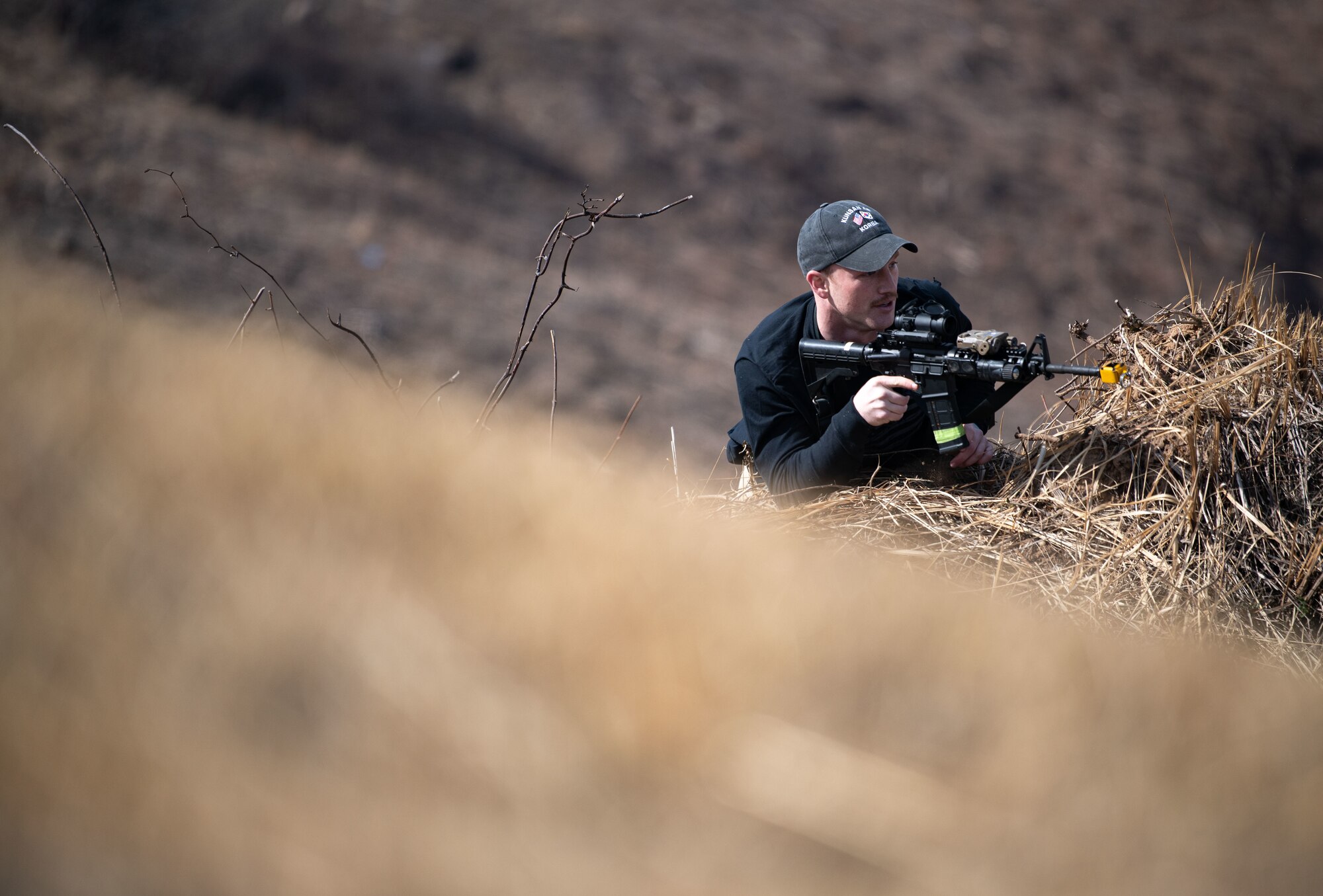 Airmen acting as an opposing force strike team prepare to ambush 8th Security Forces Squadron Defenders in order to test their ability to rapidly respond and counter base threats at Kunsan Air Base, Republic of Korea, March 10, 2022.