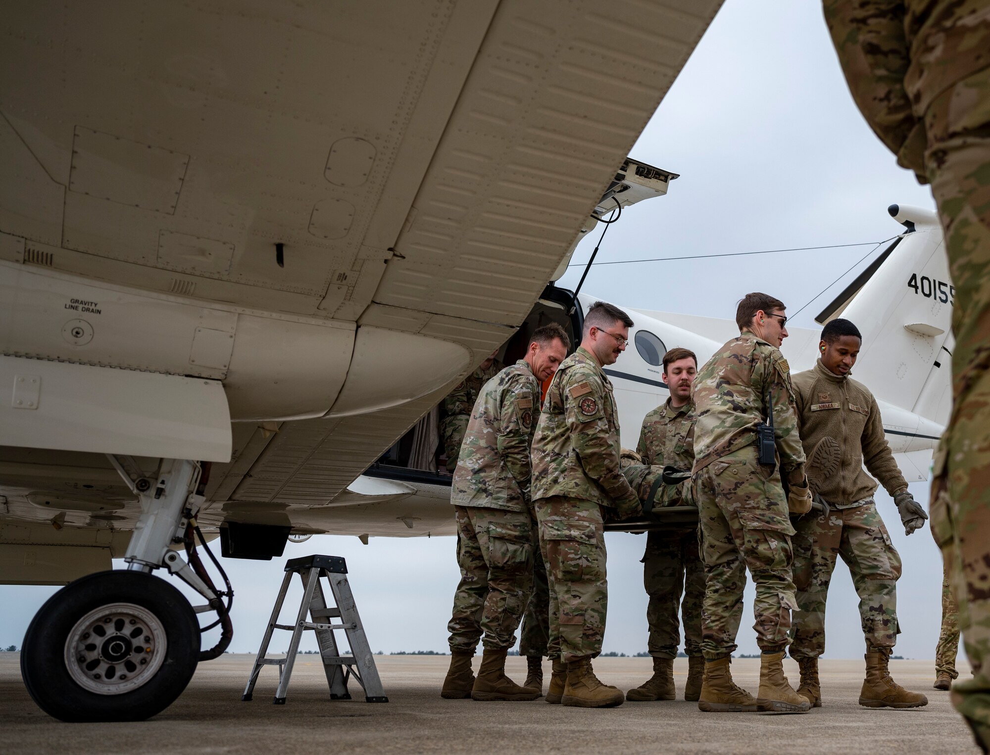 Airmen assigned to the 8th Medical Group carry a mock-casualty to a C-12 Huron during training at Kunsan Air Base, Republic of Korea, March 11, 2022.