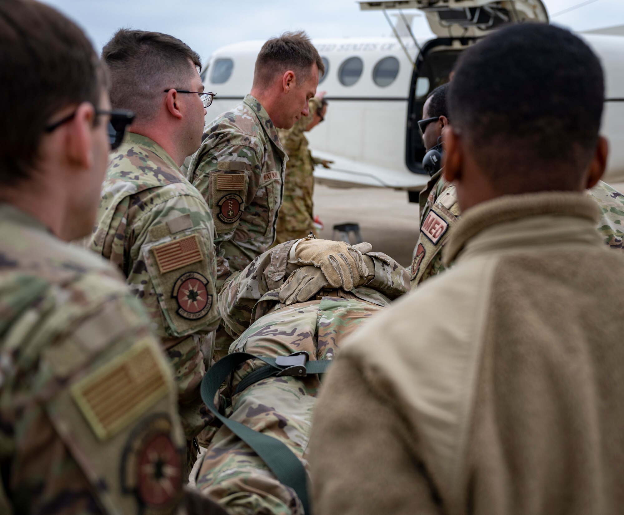 Airmen assigned to the 8th Medical Group carry a mock-casualty to a C-12 Huron during training at Kunsan Air Base, Republic of Korea, March 11, 2022.