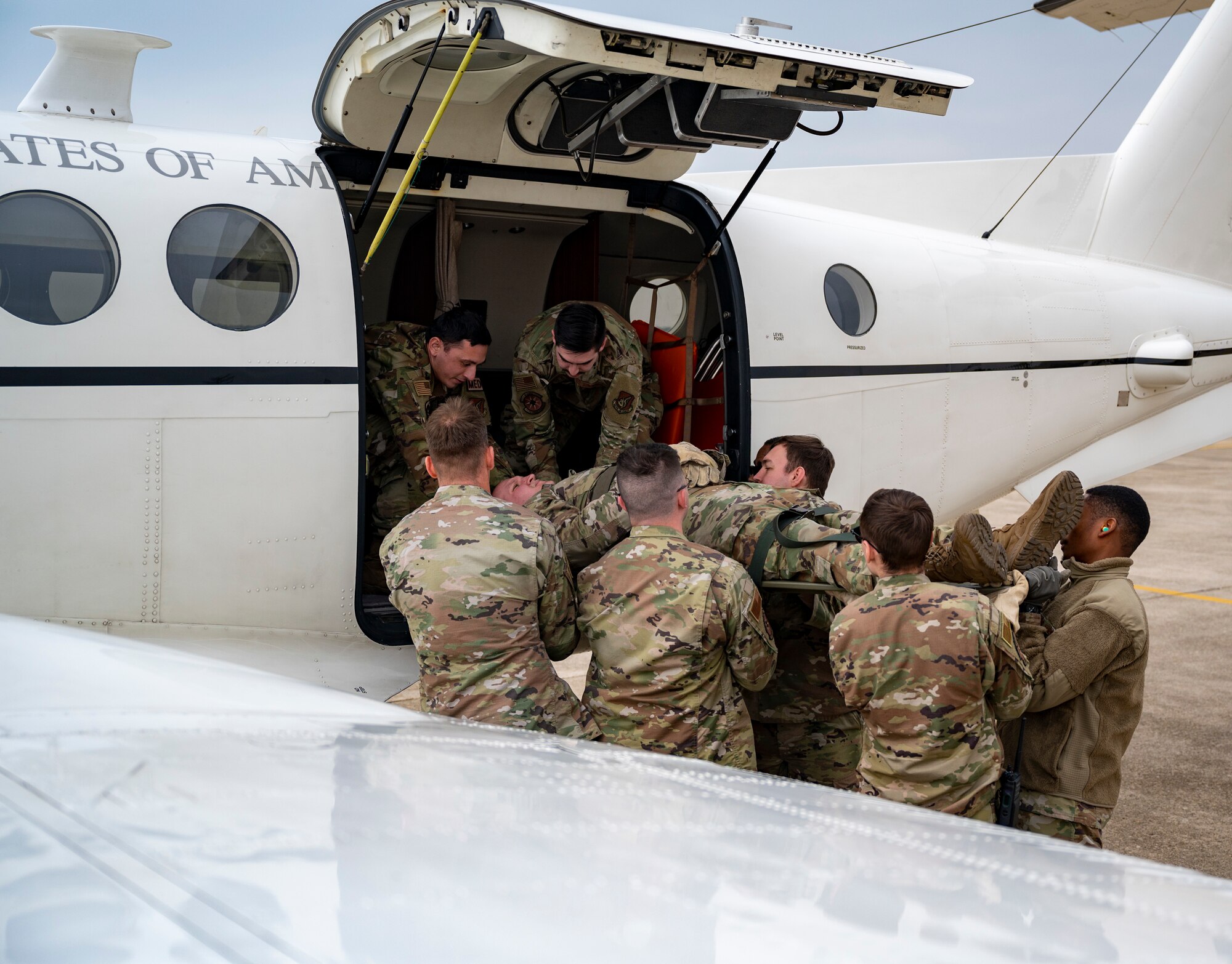 Airmen assigned to the 8th Medical Group carry a mock-casualty to a C-12 Huron during training at Kunsan Air Base, Republic of Korea, March 11, 2022.