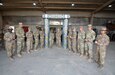 Command Sgt. Maj. Michael J. Perry III, senior enlisted advisor, 1st Theater Sustainment Command, and Command Sgt. Maj. Phelicea M. Redd, senior enlisted advisor, 1st TSC operational command post, pose with Soldiers assigned to the 389th Combat Sustainment Support Battalion at Camp Buehring, Kuwait, Mar. 2, 2022. The Soldiers, from the allied trades section of the 1063rd Support Maintenance Company, built a noncommissioned officer arch in preparation of an NCO induction ceremony scheduled later in the year.