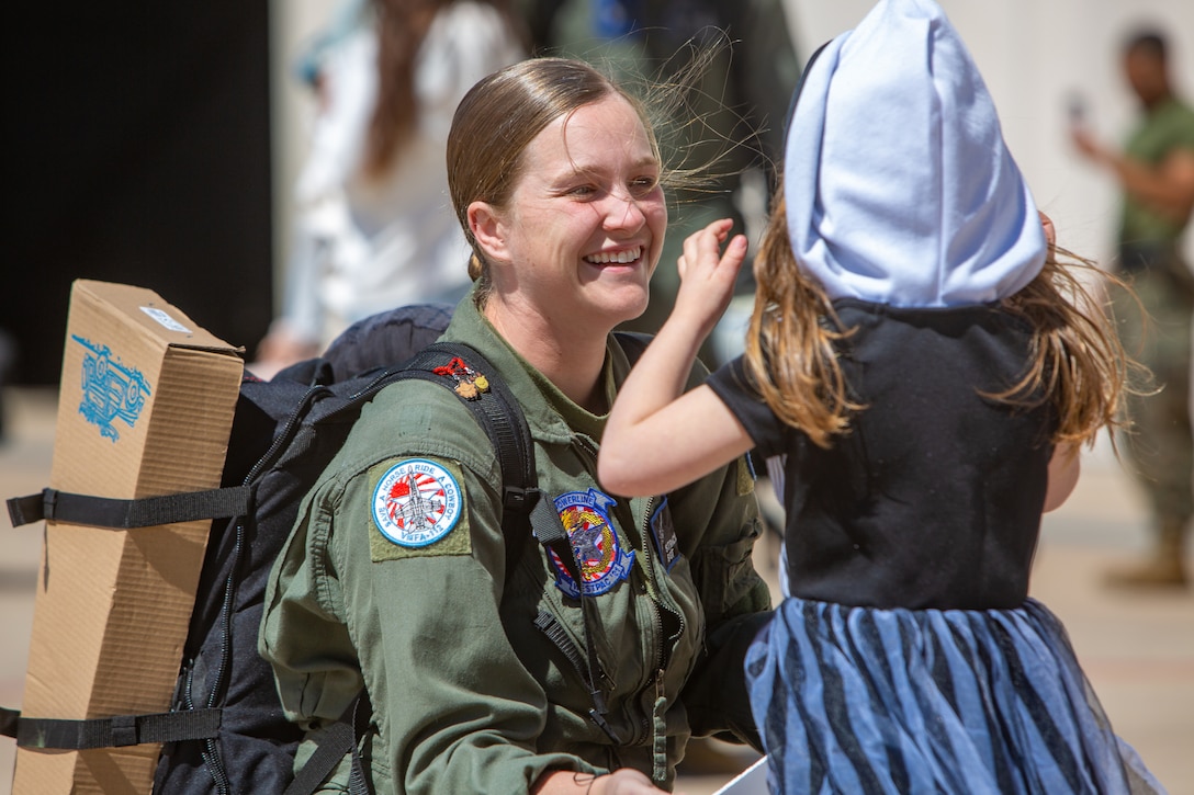 A Marine smiles as she greets a young girl.