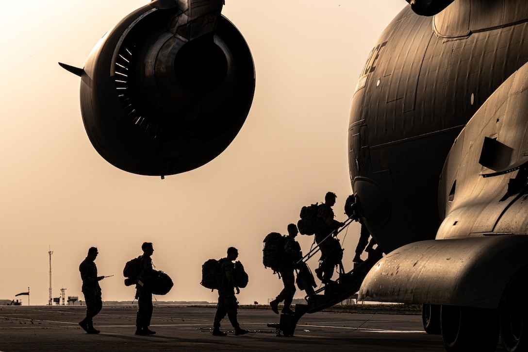 Soldiers get on board a plane.