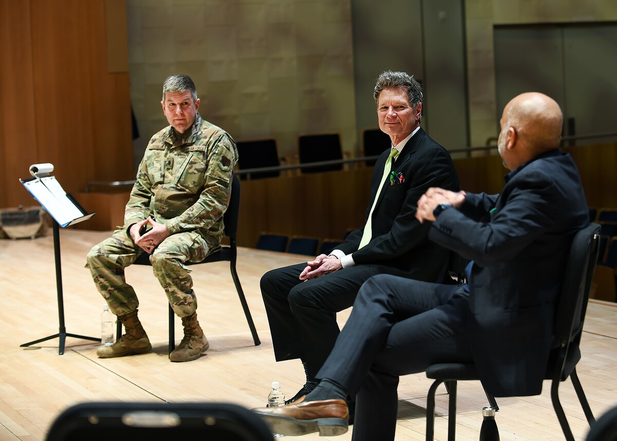 Military member listens to men talk about the importance of leadership