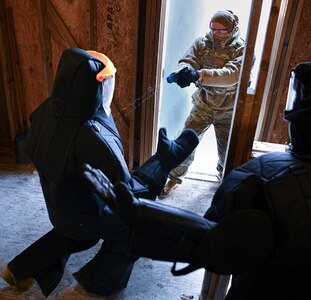 Senior Airman Christopher Buffa, a security forces member at the 109th Airlift Wing, shoots a Taser at Staff Sgt. Derek Reid, also a security forces member, during a training exercise March 5, 2022, in Scotia, New York. Reid is wearing a protective suit that shields him from the Taser.