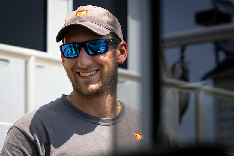 Ryan Miranda, U.S. Army Corps of Engineers, Baltimore District, survey technician, smiles as he watches a survey vessel advance the Chesapeake Bay in Baltimore, July 23, 2021. Miranda has a lifetime dedication to maritime activities and sports ranging from diving, rowing, and maritime archaeology. Now, he operates as a survey technician to safeguard the one of the largest estuaries in the nation as a federal employee in the National Capital Region. (U.S. Army photo by Greg Nash)