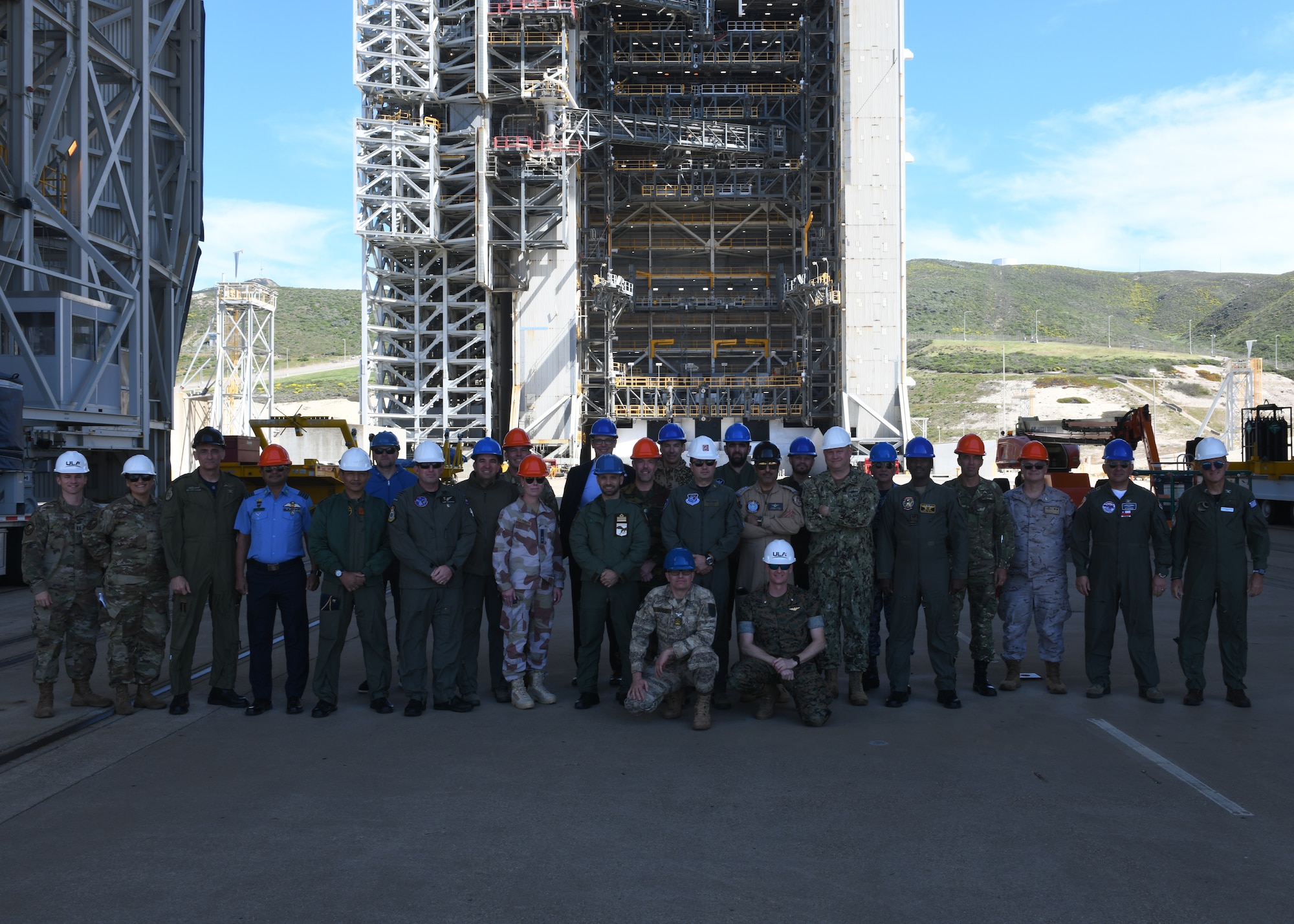 Members of the Air War College group together for a photo in front of Space Launch Complex 6 on Vandenberg Space Force Base, Calif., March 14, 2022. Officers from 21 different nations visited Vandenberg to get familiarized with combined space operations and what challenges, concerns, and opportunities they bring. (U.S. Space Force photo by Airman 1st Class Ryan Quijas)