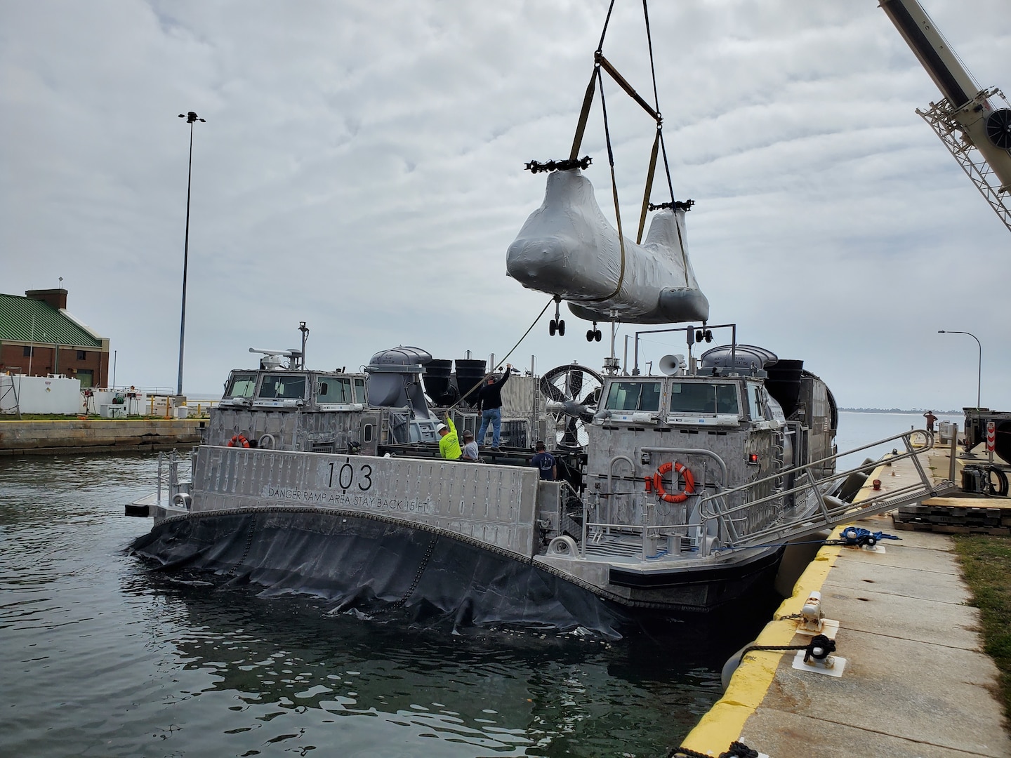 A CH-46 Sea Knight helicopter is loaded aboard Navy Landing Craft Air Cushion (LCAC) 103 at Naval Air Station Pensacola, Fla., Feb. 24. LCAC 103 transited from Panama City, Fla., to NAS Pensacola where the CH-46 was loaded and then transported to Eglin AFB to be used to support future training operations for the Air Force Special Operations Command Special Tactics Training Squadron. (U.S. Navy photo/Eric Pierce)