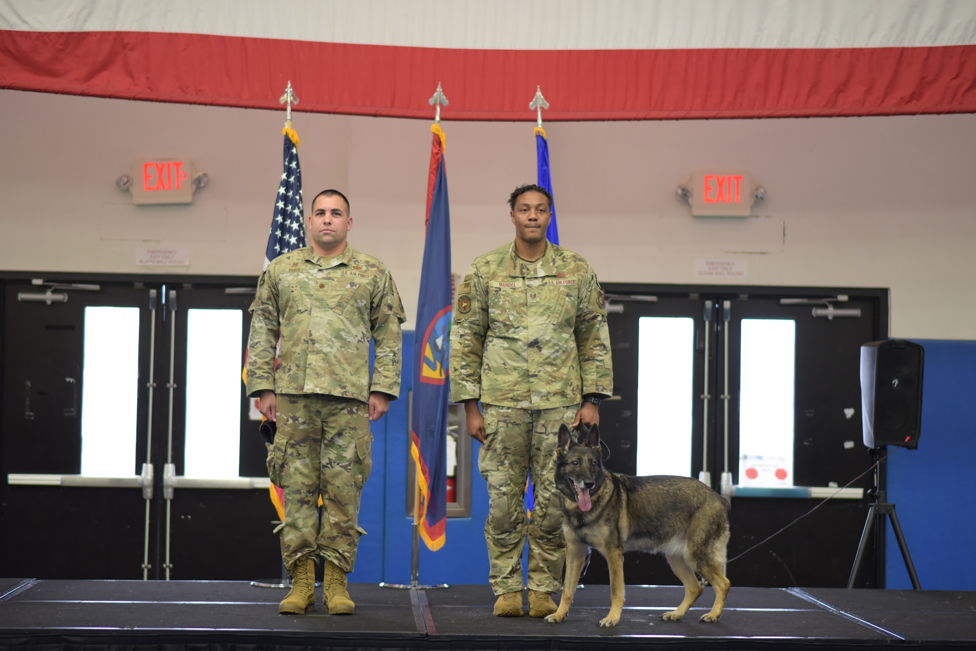 U.S. Air Force Tech. Sgt. Michael Mandel, 36th Security Forces Squadron Military Working Dog handler, escorts MWD Foxie during a retirement ceremony at Andersen Air Force Base, Guam on March 23, 2022. The ceremony recognized four MWD's with a combined 29 years of service. (U.S. Air Force photo by Airman 1st Class Emily Saxton)