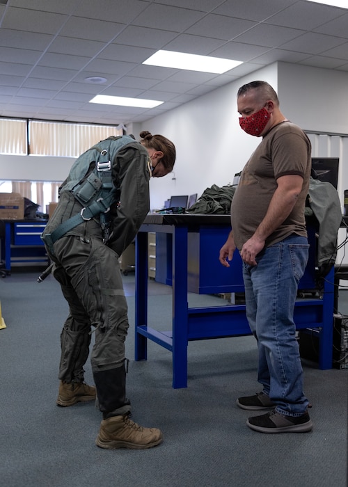 Nolan Cooney, 412th Operations Support Squadron Aircrew Flight Equipment Specialist, verifies the proper flight equipment fit for Caroline White, 412th Operations Group Standards and Evaluations Deputy Chief, as she prepares to conduct a training sortie from Edwards Air Force Base, California, March 3. (Air Force photo by Bryce Bennett)