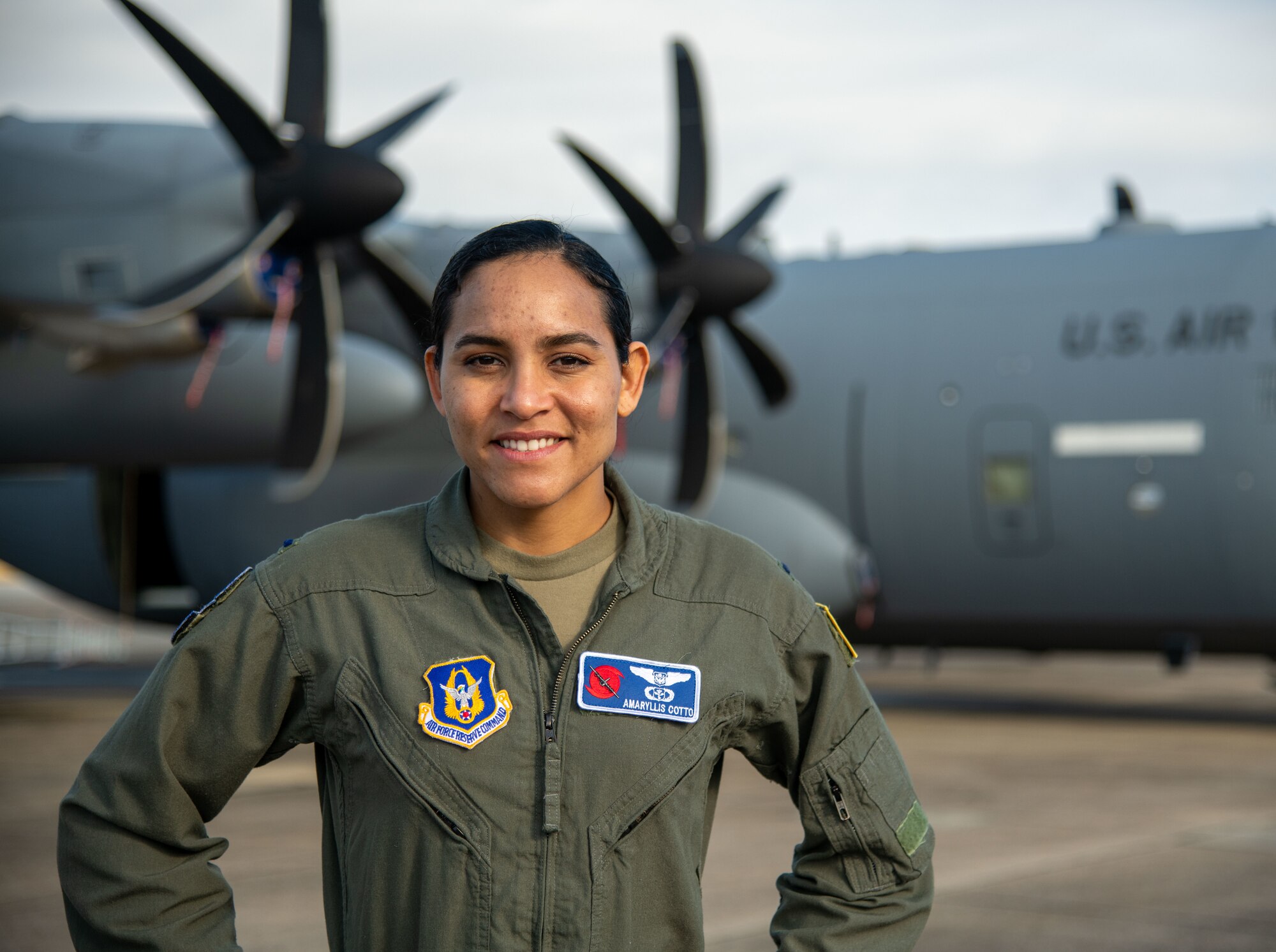 Lt. Cotto stands left/center of frame. aircraft in the background