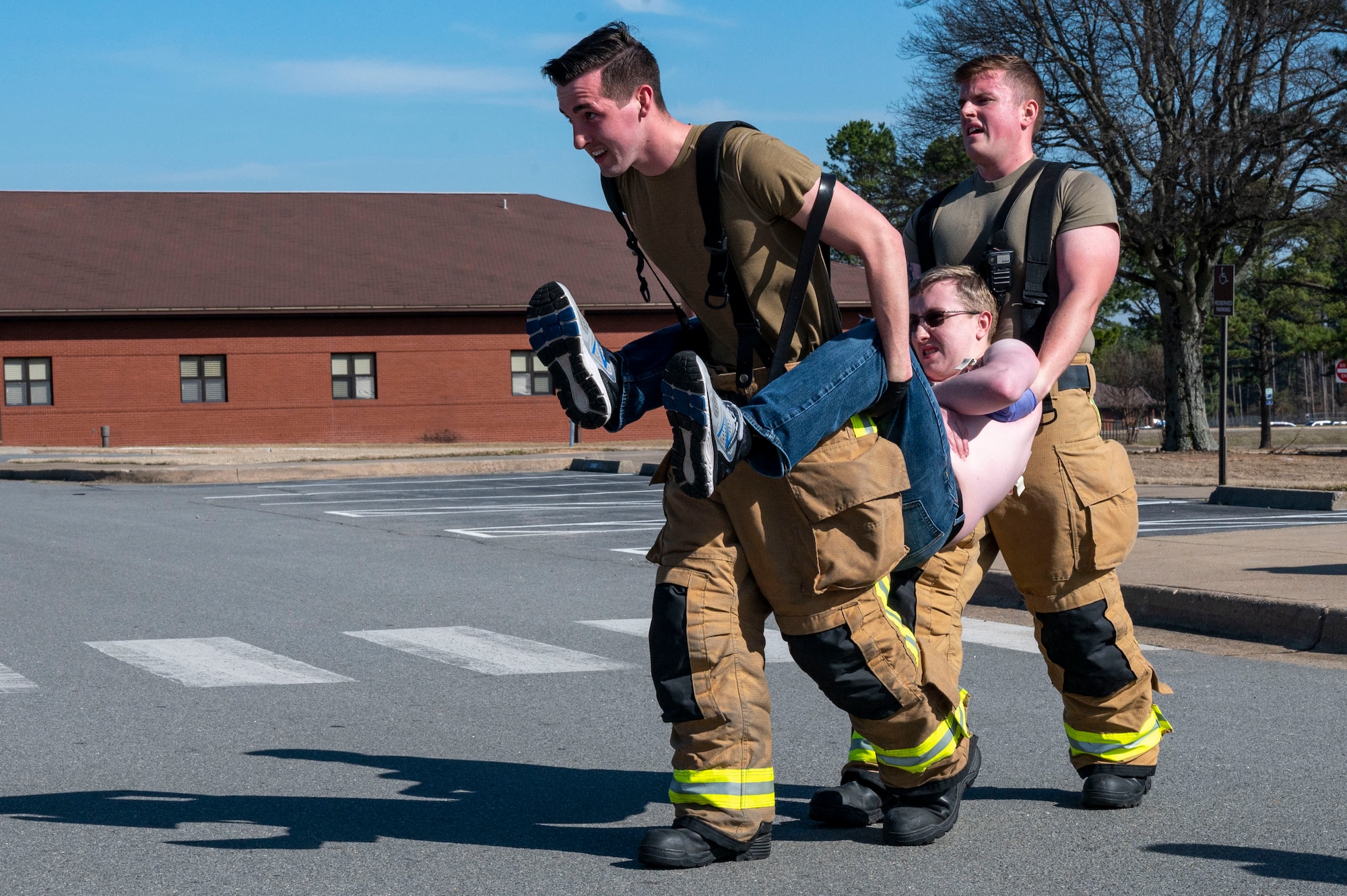 Firefighters assigned to the 19th Civil Engineer Squadron Fire Department carry a man out of a building