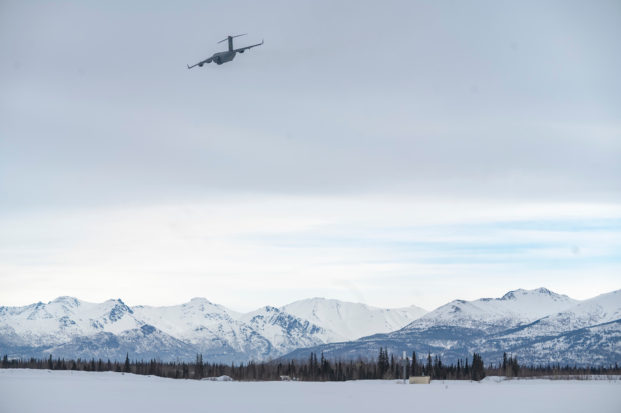 C-17 Globemaster III assigned to Joint Base Lewis-McChord, Washington, flies over Joint Base Elmendorf-Richardson, Alaska, during Exercise Rainer War 22-A March 18, 2022. The exercise is designed to demonstrate the wing’s ability to operate and survive while defeating challenges to the U.S. military advantage in all operating domains – air, land, sea and cyberspace. (U.S. Air Force photo by Airman 1st Class Charles Casner)