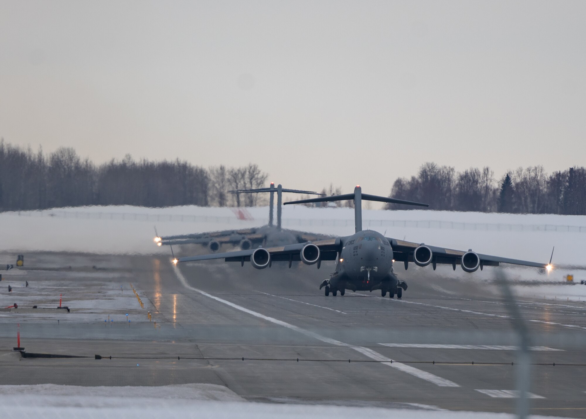 Three C-17 Globemaster IIIs assigned to Joint Base Lewis-McChord, Washington, take off from a runway during Exercise Rainer War 22-A at Joint Base Elmendorf-Richardson, Alaska, March 18, 2022. The exercise is designed to demonstrate the wing’s ability to operate and survive while defeating challenges to the U.S. military advantage in all operating domains – air, land, sea and cyberspace.(U.S. Air Force photo by Airman 1st Class Charles Casner)