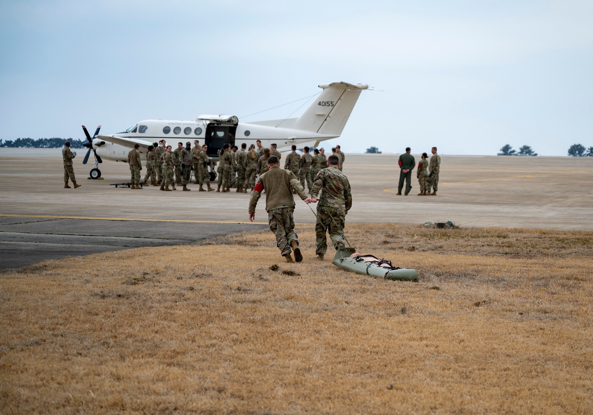 Airmen assigned to the 8th Medical Group carry a mock-casualty to a C-12 Huron during training at Kunsan Air Base, Republic of Korea, March 11, 2022.