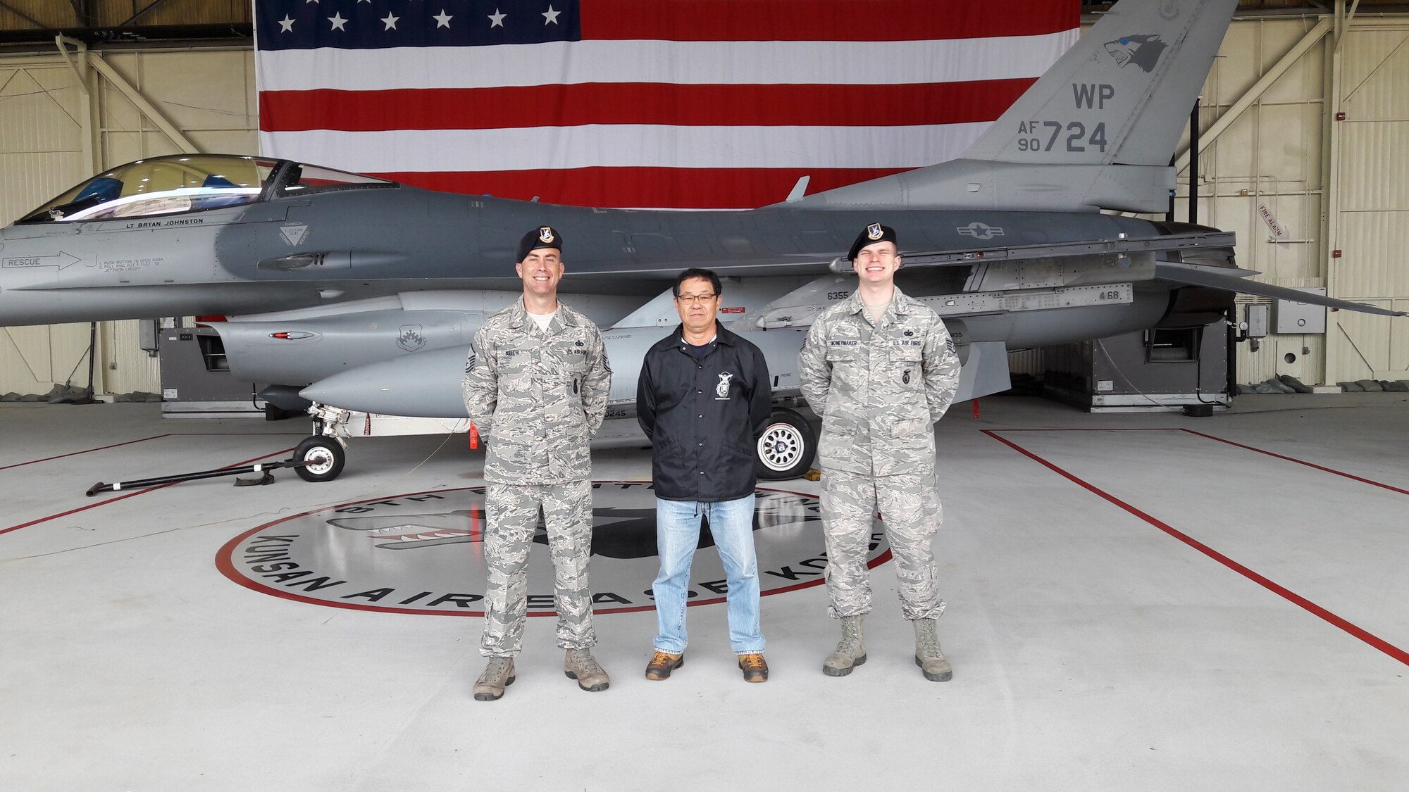 A civilian smiles with Airmen.