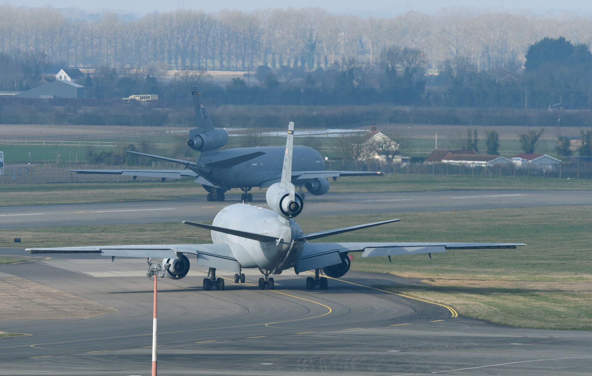 Two U.S. Air Force KC-10 Extender aircraft assigned to the 305th Air Mobility Wing, Joint Base McGuire-Dix-Lakehurst, N.J., prepare to take off at Royal Air Force Mildenhall, England, March 10, 2022. The KC-10 is an Air Mobility Command advanced tanker and cargo aircraft designed to provide increased global mobility for U.S. Armed Forces. (U.S. Air Force photo by Karen Abeyasekere)