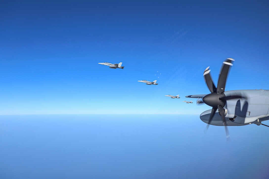 A group of fighter jets fly in a blue sky.