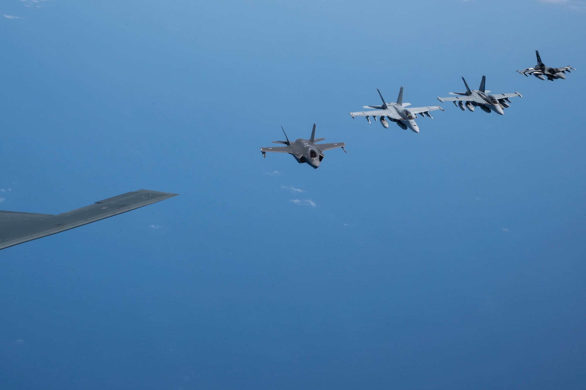 A U.S. Air force B-2 Spirit from Whiteman Air Force Base, Missouri, flies in formation with a Royal Australian Air Force F-35A Lightning IIs, two EA-18 Growlers, two RAAF F/A-18F Super Hornets and two U.S. Air Force F-16C Aggressors from Eielson Air Force Base, Alaska during a CONUS-to-CONUS training mission in the Indo-Pacific region, March 23, 2022. After integrating in Australian airspace, the B-2 pilots landed at Amberley—for the first time ever—and conducted a crew swap on the ground before becoming airborne and integrating with F-22 Raptors from Joint Base Pearl Harbor-Hickam, Hawaii, then returning back to Whiteman. (U.S. Air Force photo by Tech. Sgt. Hailey Haux)