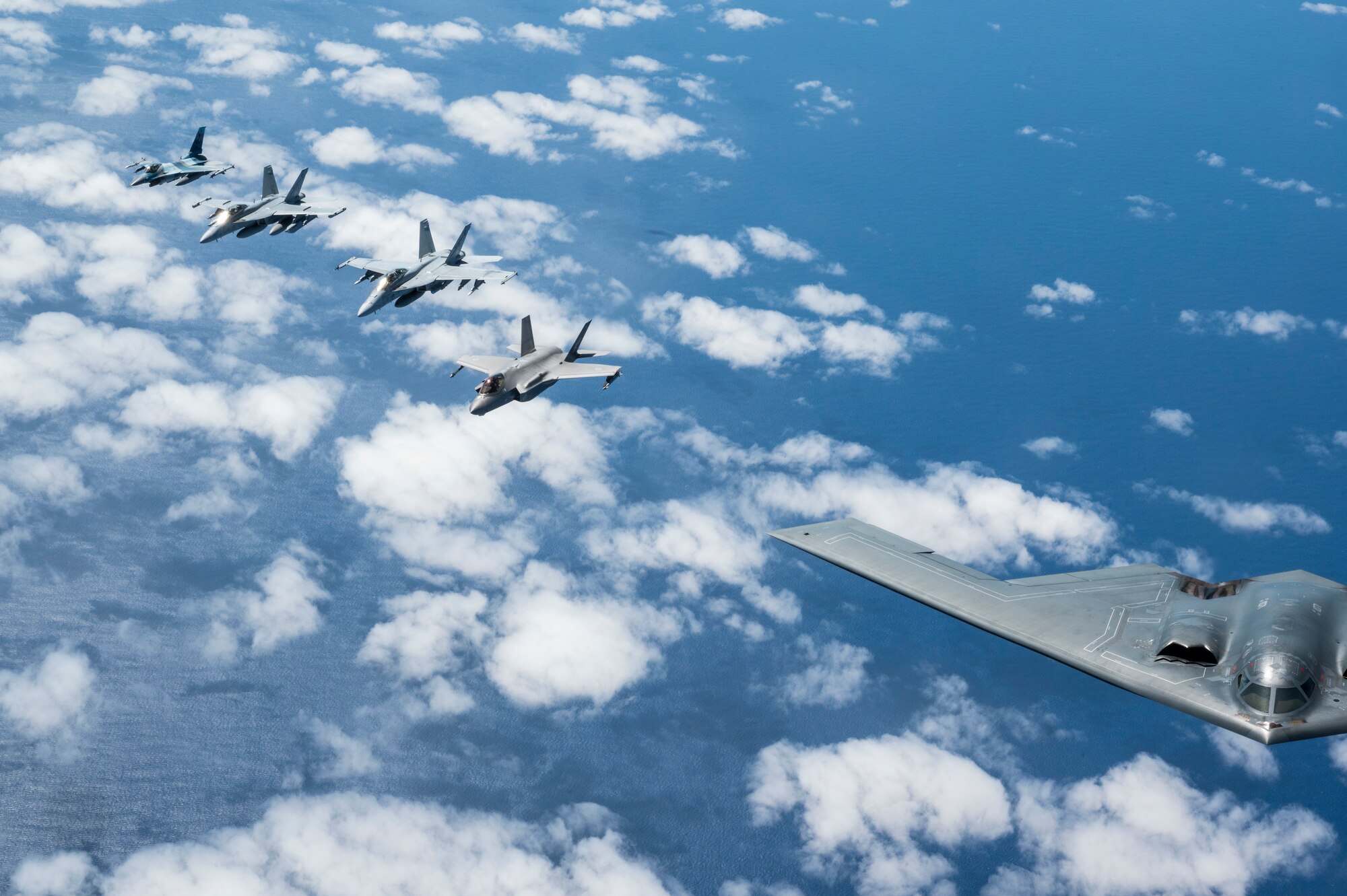 A U.S. Air force B-2 Spirit from Whiteman Air Force Base, Missouri, flies in formation with a Royal Australian Air Force F-35A Lightning IIs, two EA-18 Growlers, two RAAF F/A-18F Super Hornets and two U.S. Air Force F-16C Aggressors from Eielson Air Force Base, Alaska during a training mission in the Indo-Pacific region, March 23, 2022. The U.S. trains alongside allies and partners to demonstrate interoperability and bolster collective ability to support a free and open Indo-Pacific and this most recent mission was no exception. (U.S. Air Force photo by Tech. Sgt. Hailey Haux)