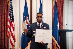Brig. Gen. Terrence A. Adams, Concepts and Strategy Air Force Futures Military deputy director, Headquarters U.S. Air Force, displays the President Joseph R. Biden Lifetime Achievement Award he received during a ceremony in Washington, D.C., March 20, 2022. Adams earned the award for championing STEM and cybersecurity in the youth community. (U.S. Air Force photo by Staff Sgt. Elora J. McCutcheon)
