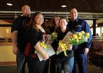 Caroline Leo and Holly Wilson, ombudsmen for Coast Guard Cutter Alex Haley, pause for a photo with their family and Cmdr. Stephen White, commanding officer of Alex Haley, during a luncheon in Kodiak, Alaska, April 4, 2014. The luncheon was held in honor of the ombudsmen who help Coast Guard families have the information necessary to meet the challenges of a military lifestyle. (U.S. Coast Guard photo by Petty Officer 3rd Class Diana Honings)