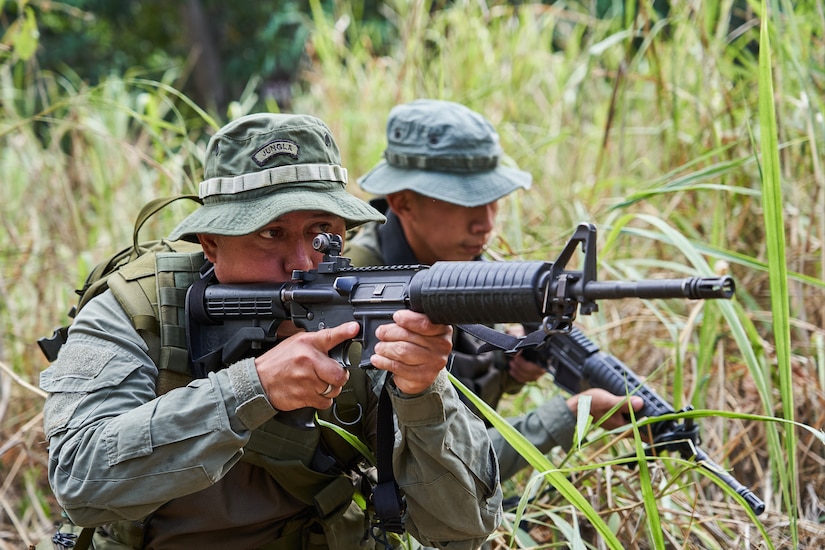 Soldiers hold guns