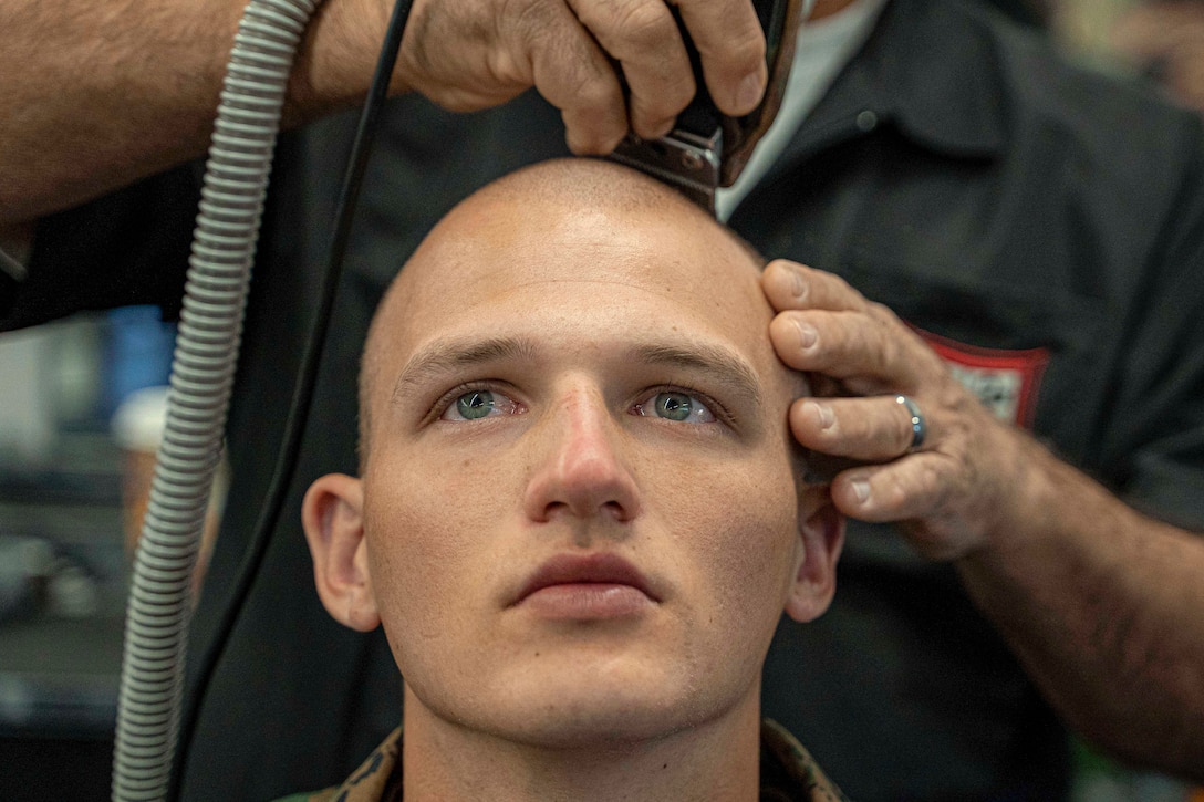 A Marine Corps recruit gets a haircut.