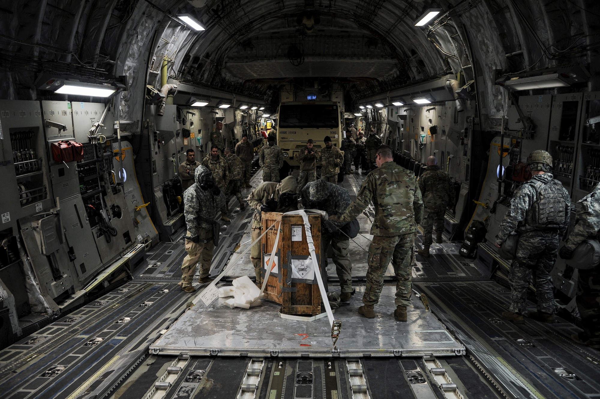 Soldiers, cargo and vehicle aboard an aircraft.