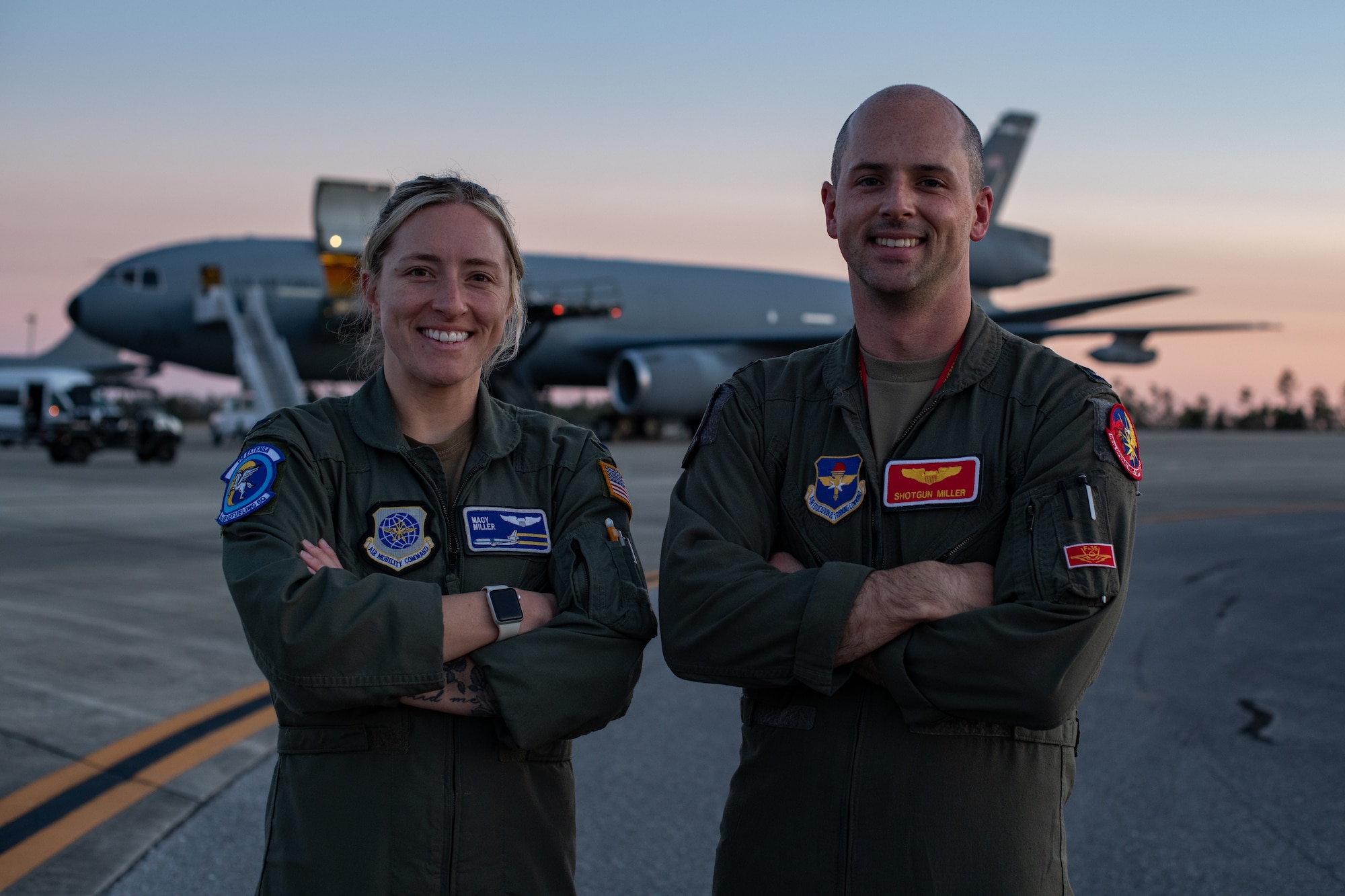 man and woman pose for photo on flight line
