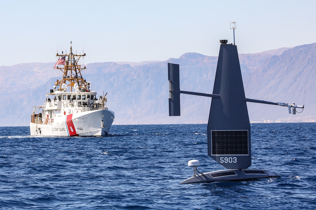 A Coast Guard ship sails near a floating drone.