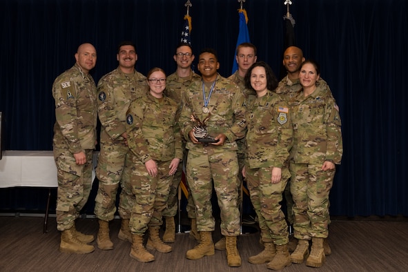 Airman accepts award with team