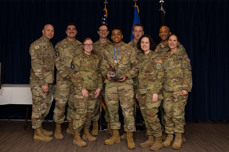Airman accepts award with team
