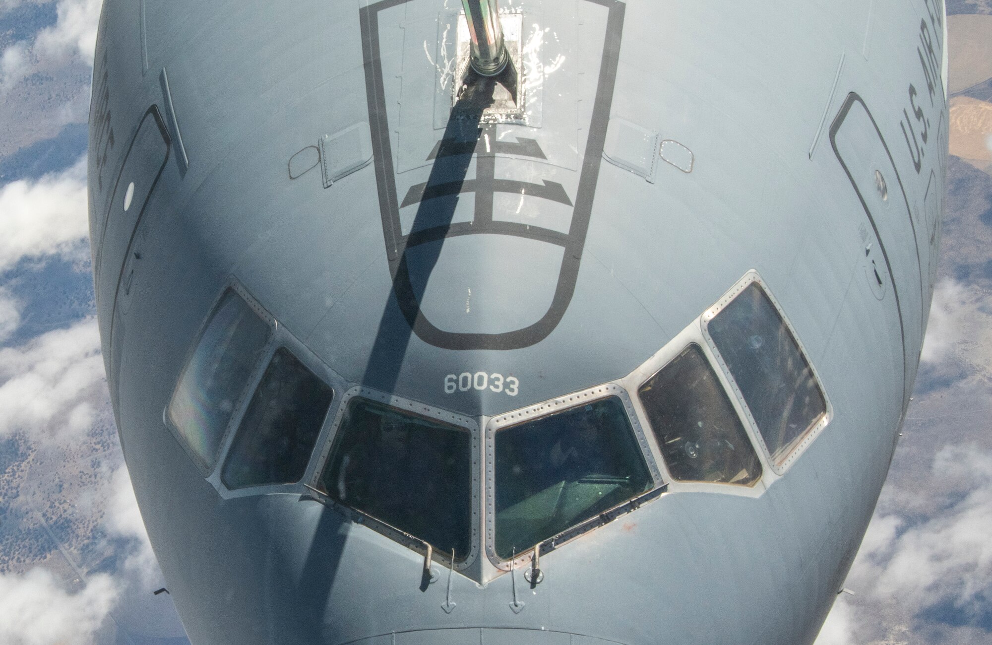 an airplane moves fuel from one plane to another with a large metal hose