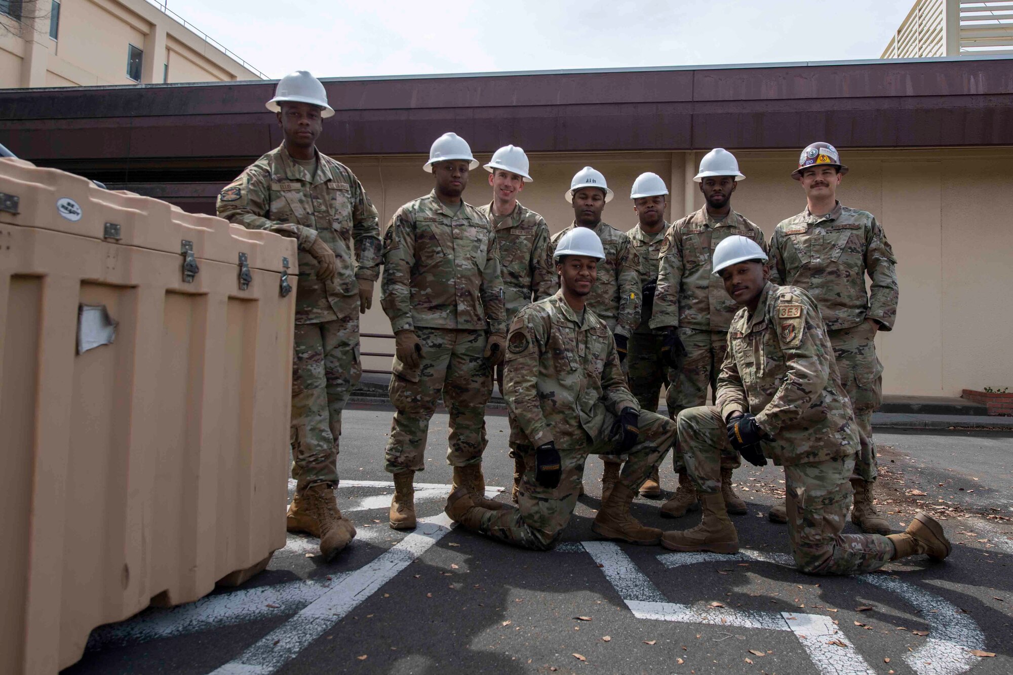 Deployed Airmen from the 117th Civil Engineer Squadron, Sumpter Smith Joint National Guard Base, Alabama, and the 908th CES, Maxwell Air Force Base, Alabama pose for photo after removing the COVID tent at Yokota Air Base, Japan, March 23, 2022.